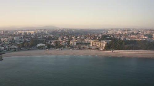 Aerial view of marginal over ocean in Santo amaro beach of Oeiras, sunset in Portugal - drone shot I