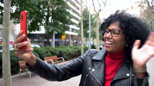 Middleaged African American Woman in a City Making a Video Call in a City with a Mobile Phone