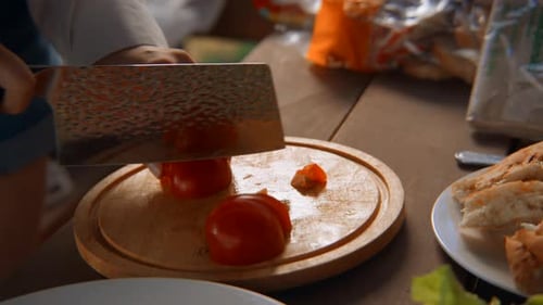 Close-up of chef slicing tomatoes on board