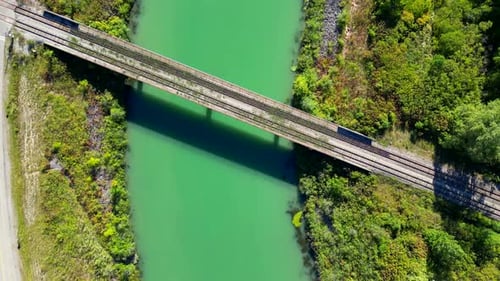Aerial Drone Overhead Train Bridge Crossing River Surrounding Green Vegetation