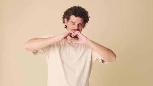 Smiling Man Makes Heart Shape With Hands