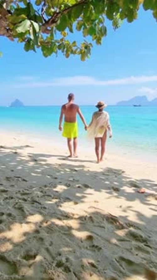 Couple Strolling on Sandy Beach By Water Holding Hands Under Vast Sky Koh Kradan Thailand