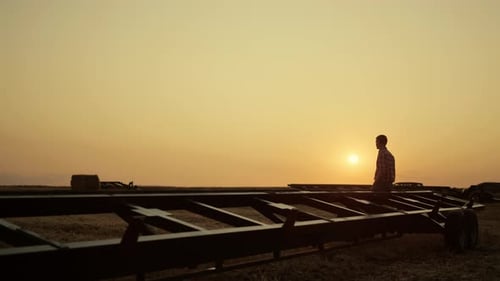 Man Silhouette Standing Wheat Field with Machinery. Agronomist Examine Thresher Crop Combine