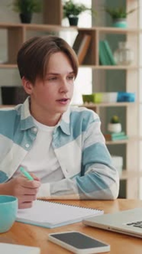 Teen Doing Homework and Writing at Desk