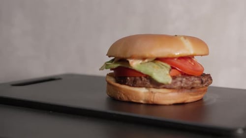 Juicy Burger with Toasted Bun on Cutting Board