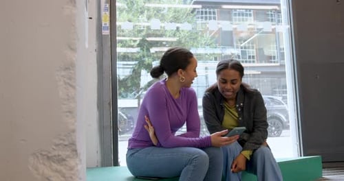 Two Young Women Looking at a Smartphone Together
