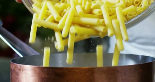 slow motion of Italian pasta typical that falls inside a full pot of boiling water to cook the Ita