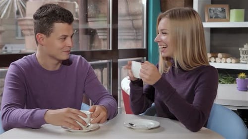 Couple Enjoys a Delightful Conversation at a Cozy Cafe