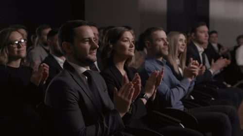 Enthusiastic business crowd applauds welcoming speech at economic summit meeting