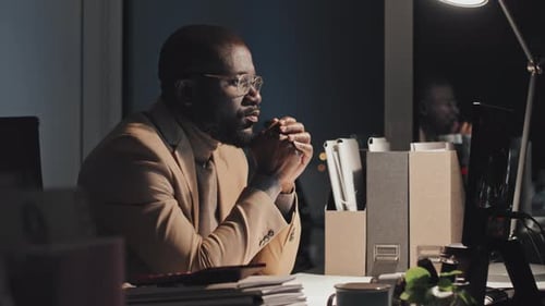 Sleepy Black Businessman Working on Computer at Night