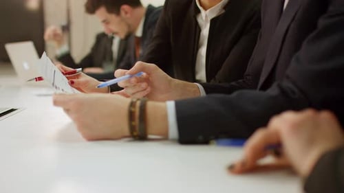 Close-Up of Hands Going Through Notes During Business Meeting