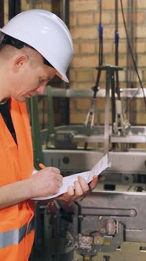 Engineer Inspects Quality of Elevator Parts Complex Modern Elevator Equipment Male Utility Worker