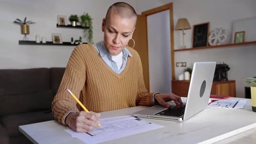 Freiberufliche Architektin, Innenarchitektin, arbeitet zu Hause mit Laptop und zeichnet Baupläne
