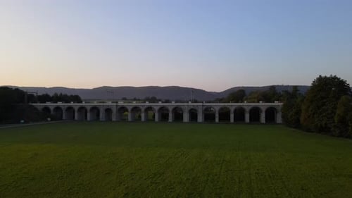 Aerial view of a train viaduct with the surrounding countryside and the city lying in the background