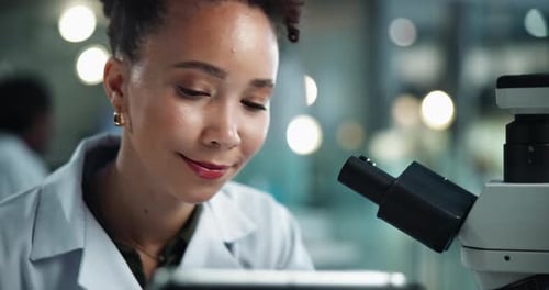 Female Scientist Using Microscope in Modern Lab