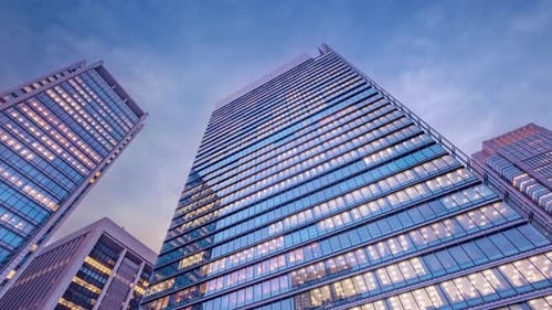 Twilight sky time lapse view looking up at modern office building.