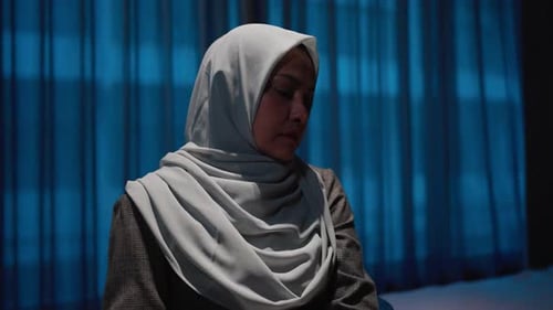 Woman Wearing Headscarf Sits Indoors