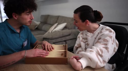 Man and Woman Playing Backgammon at Table Indoors