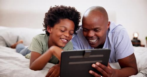 Happy Boy and Man Use Tablet on Bed