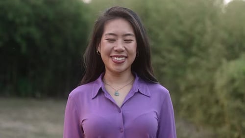 Jeune femme asiatique calme souriante et cherchant à filmer une émotion humaine zen positive