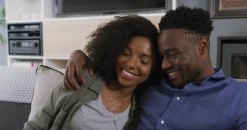 Loving Couple Smiling on Sofa Together at Home