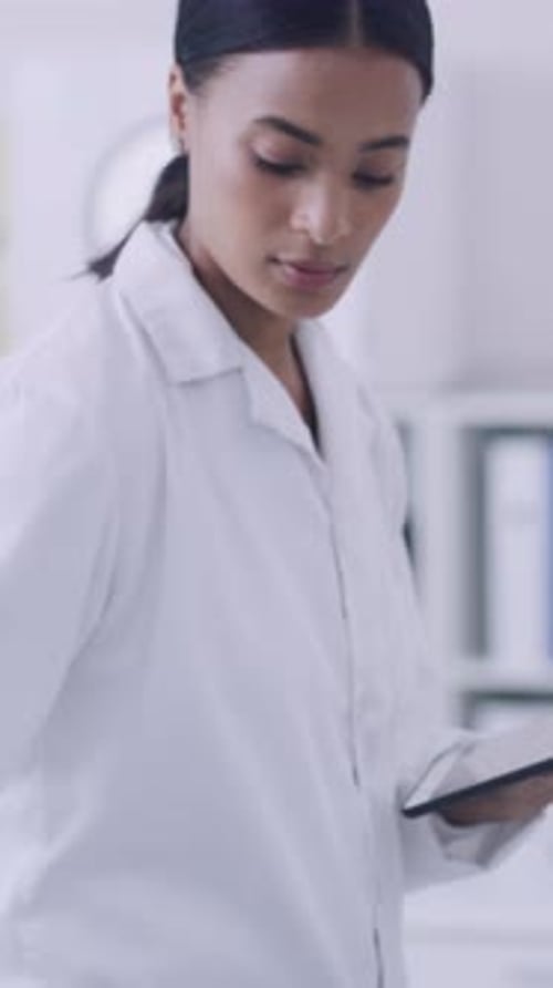 Woman in Lab Coat Using Tablet in Lab