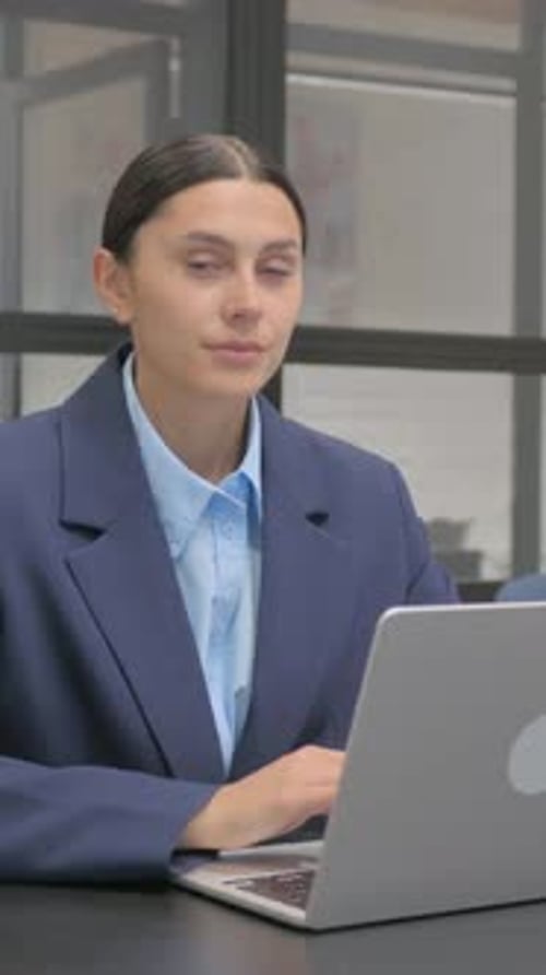 Smiling Woman Works at Laptop in Modern Office