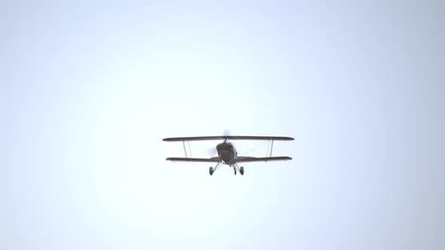 Vorderansicht eines fliegenden Doppeldeckers mit rotierendem Propeller SLOMO