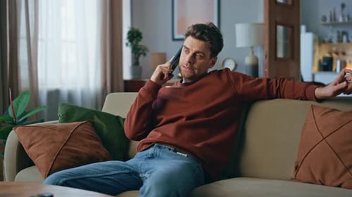 Man Talking on Phone While Relaxing on Couch
