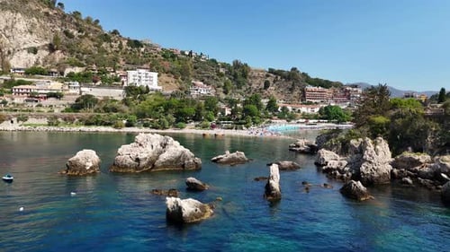 Coastal town with rocky beach and clear blue water on a sunny day