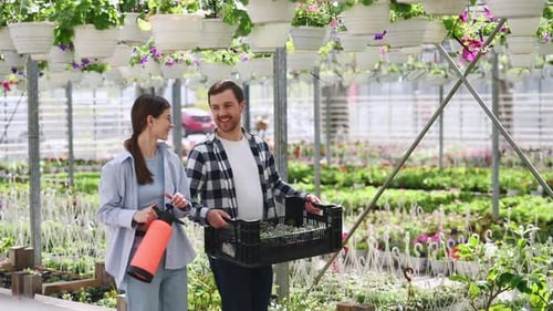 Couple Shopping for Plants at Sunny Greenhouse