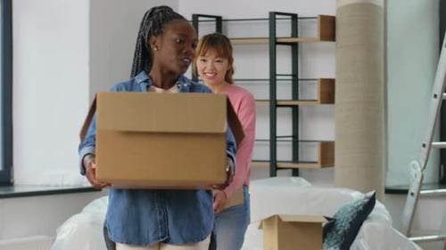 Moving, People and Real Estate Concept - Women Packing Boxes at Home Accommodation