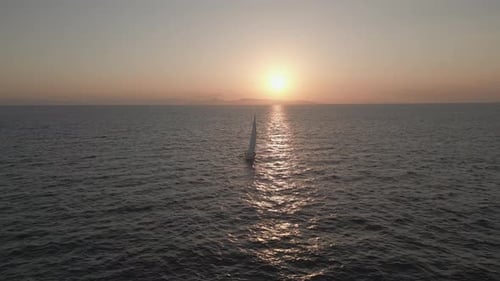 Sailboat Gliding on Ocean at Sunset