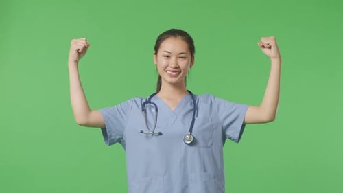 Asian Female Doctor With Stethoscope Smile And Flex Muscle On Green Screen Background