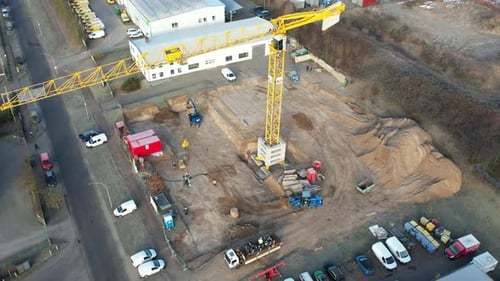 a large yellow construction crane and various construction machines are used on a construction site
