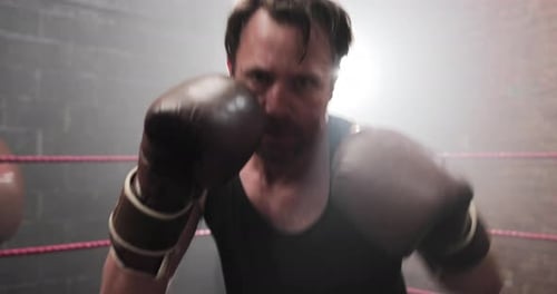 Intense Boxer Shadow Boxing in Foggy Urban Gym