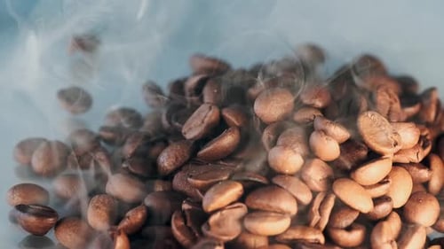 El humo proviene de granos de café aromáticos ligeramente tostados que se encuentran en un montón de cerca