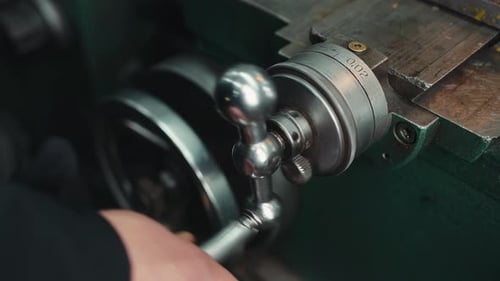 Fine tuning of a lathe before work, close-up a turner's hand adjusts a metalworking lathe