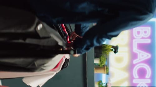 Shop Worker Assisting Customer With Clothing Selection