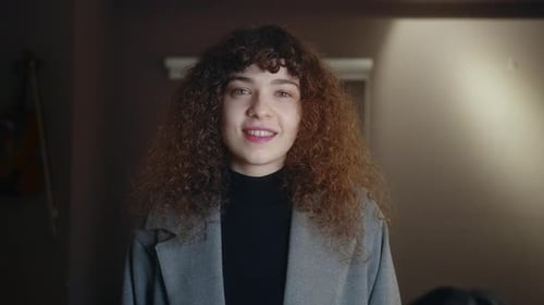 Smiling Woman with Curly Hair Looking at Camera