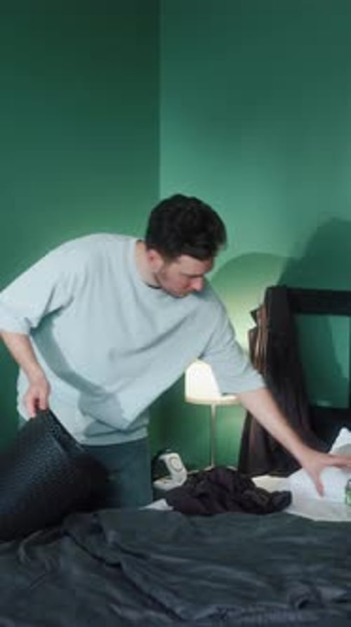 Man Cleaning Bed in Modern Bedroom
