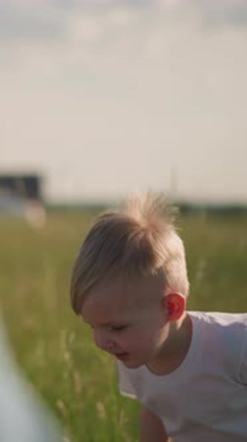 Kid Joyfully Jumping in a Sunny Grass Field with Blurred Background