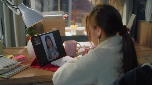 Young Woman having Video Call while Studying