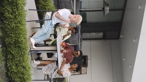 Group of multiethnic friends enjoy a sunny afternoon together at an outdoor cafe