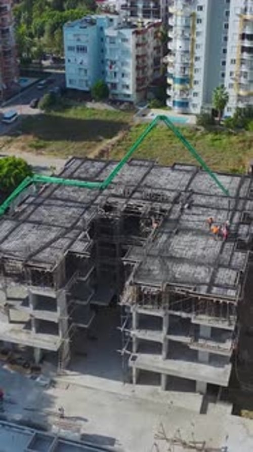 Vertical Video Team Pouring Concrete and Handling Equipment on a Residential Building Site