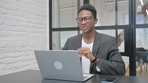 Young Man Video Call on Laptop in Office