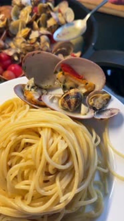 De délicieux spaghettis aux palourdes et à une salade de légumes mélangés sont un plat italien authentique