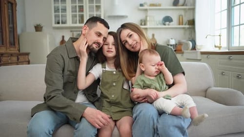 Happy Family Relaxing Together on Couch at Home