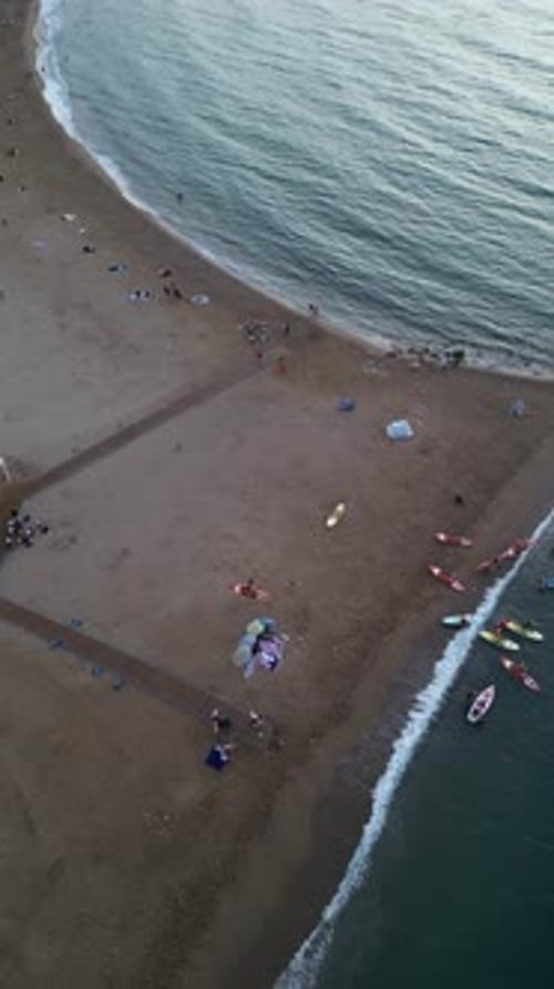 Aerial video on Barcelona's coastline people doing a sap.