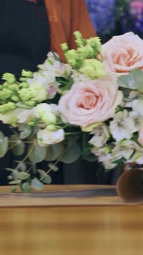 Making a Bouquet in a Flower Shop Closeup of Wrapping a Bouquet in Craft Paper Florist Hands